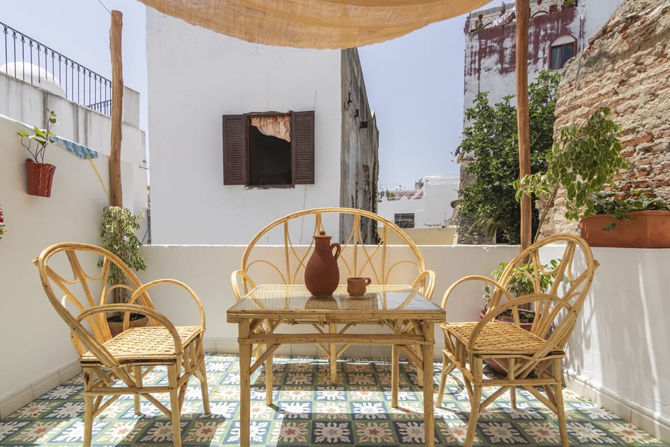 Unwind and take in panoramic views of Tangier from our rooftop terrace, featuring a charming cane table.