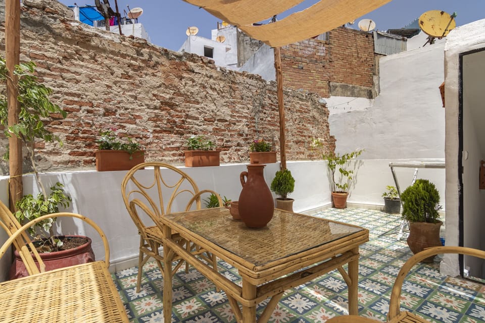 Enjoy a cup of tea with a view on our rooftop terrace, furnished with a traditional cane table.