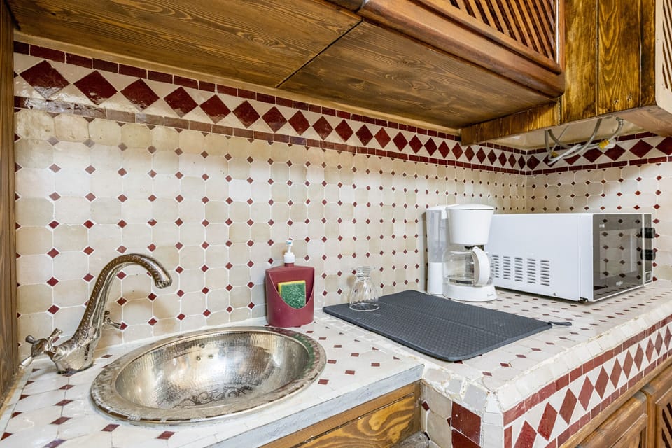 Well-equipped kitchenette with a sink, microwave, and coffee maker, perfect for preparing light meals and beverages during your stay.