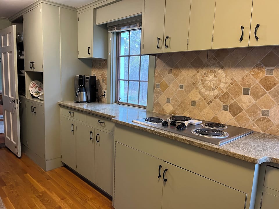 Kitchen, green granite counter tops, drip coffee maker out, Keurig in cabinet.