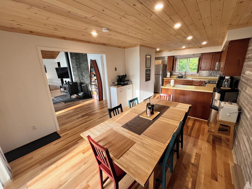 The open dining and kitchen area with wooden cabinetry and modern appliances offers a comfortable and convenient space for preparing and enjoying meals.