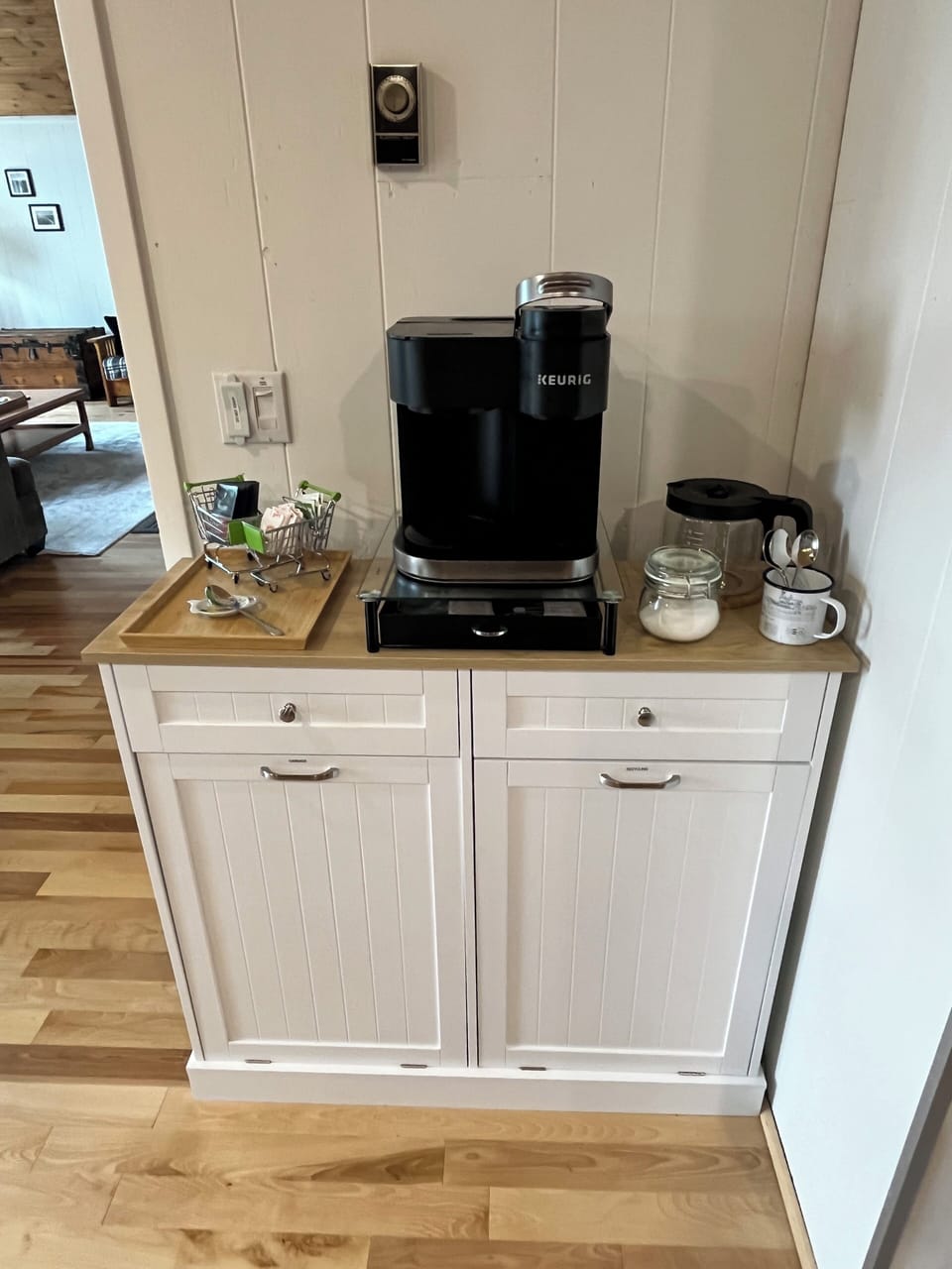 A convenient coffee station with a Keurig machine, coffee essentials, and a neat storage cabinet, adding a practical touch to the cozy cabin.