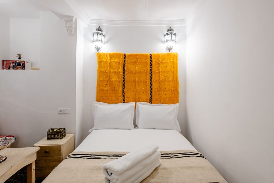 The sleeping area features a king-size bed and a window letting in natural light
