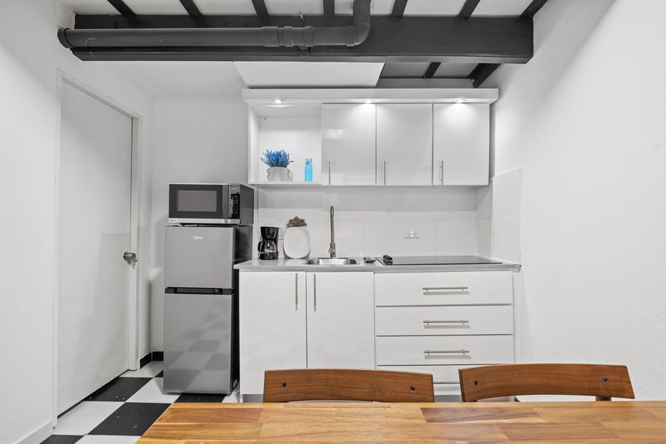 The compact but fully equipped kitchen with a mid-size fridge, 4-stove burner, microwave and coffee maker.