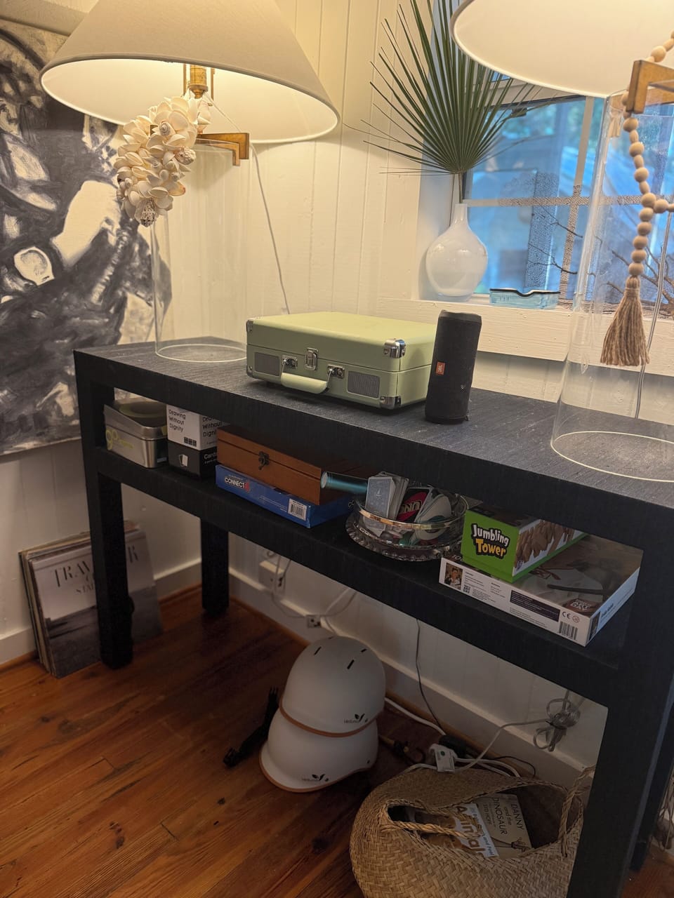 Game console, bike helmets, JBL wireless speaker, record player and records.