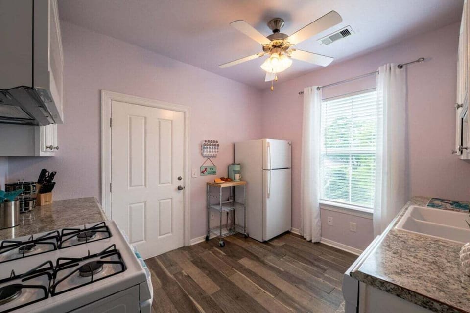 Open kitchen and dining area with spacious layout, ceiling fan, natural lighting, and functional setup ideal for family vacations.