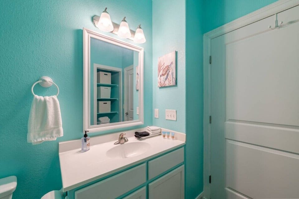 Modern bathroom with extended vanity counter, framed mirror, bright lighting, and coastal-inspired design perfect for family vacation convenience.