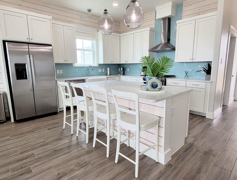 The open kitchen has stainless appliances and grantie counters