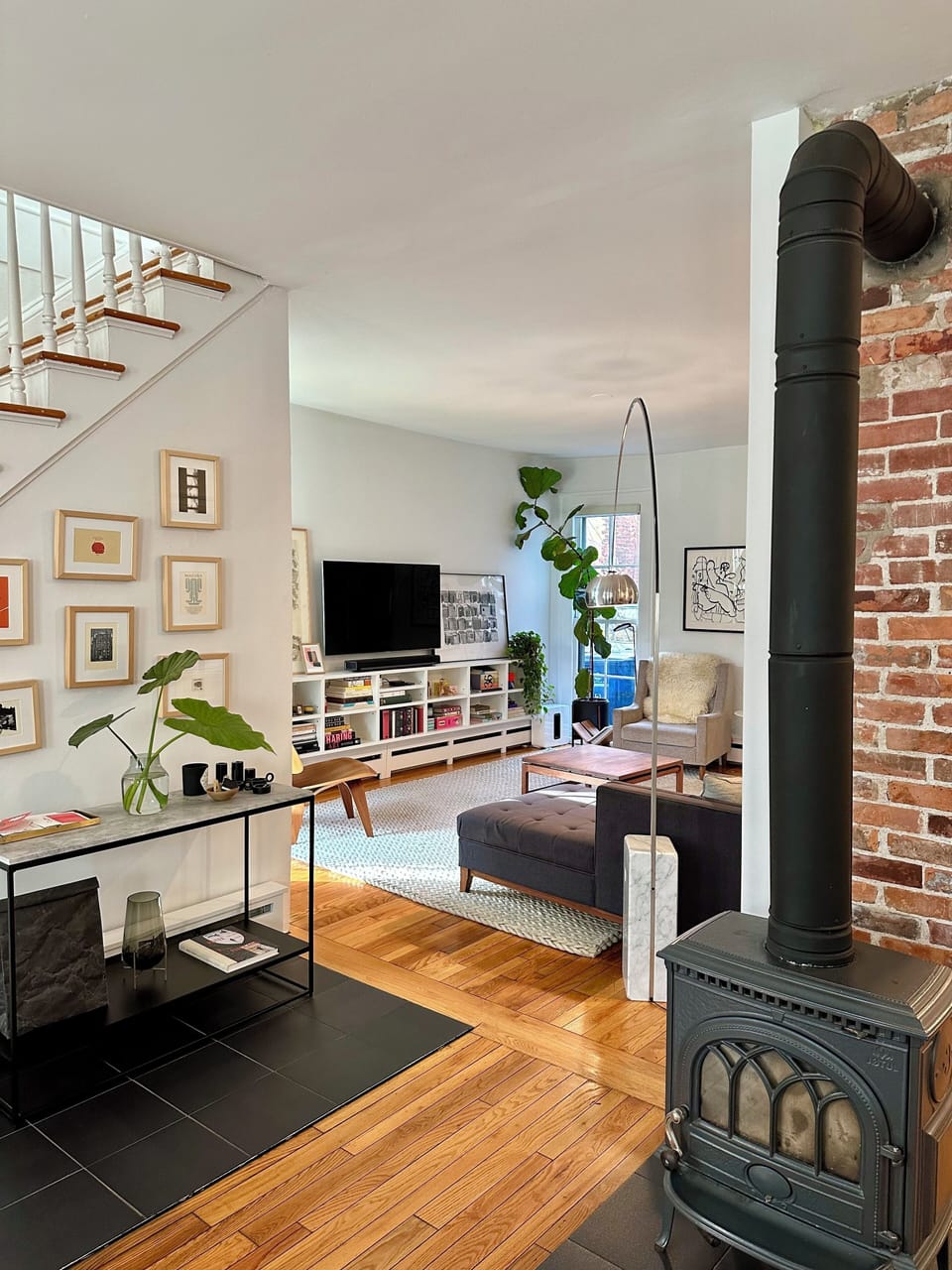 Living room with local art, design books, cozy blankets, smart TV, and Sonos.