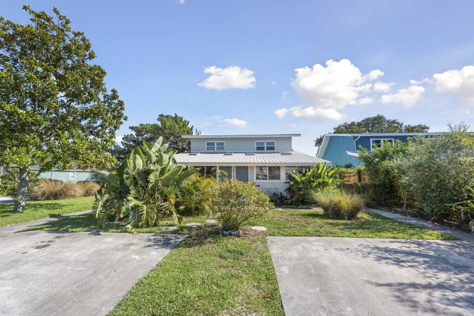 Charming Exterior: Escape to a tropical paradise with vibrant landscape and welcoming entryway!