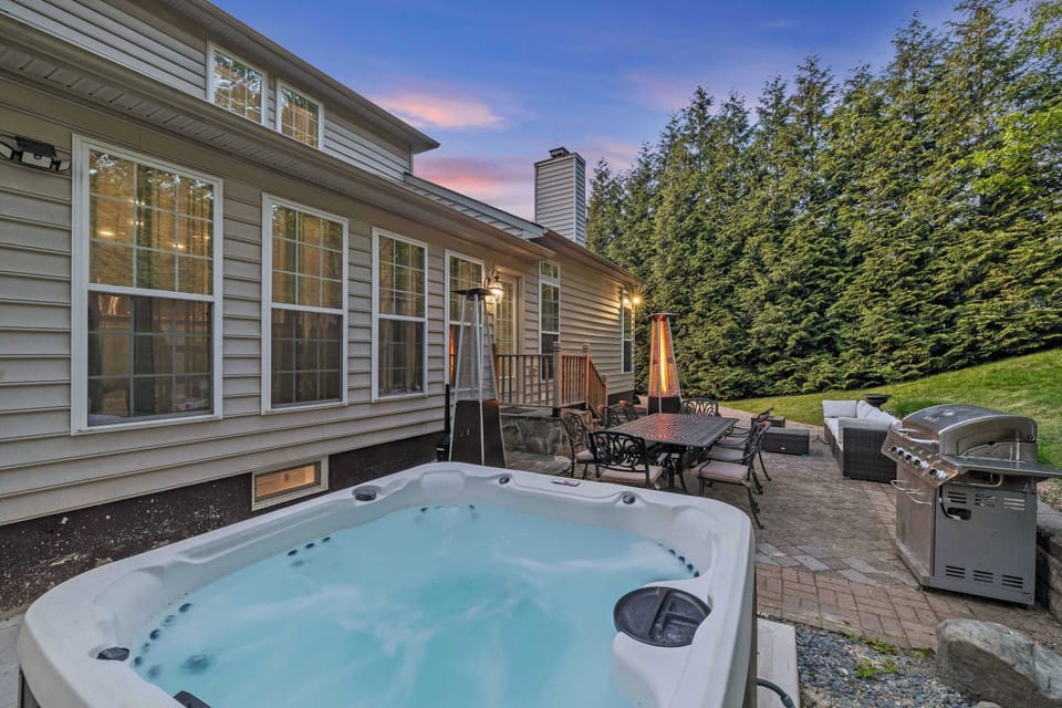 Ease into the hot tub as dusk settles over the patio — the grill's within reach and the trees close in around you.