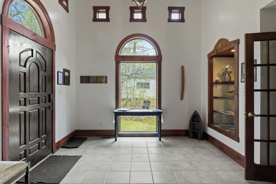 Front Entrance (second floor) - Step into elegance at this Seneca Lake hideaway, where the stunning arched doorway and bright, airy entryway instantly evoke a sense of peace and sophistication. Ideal for a tranquil retreat. 