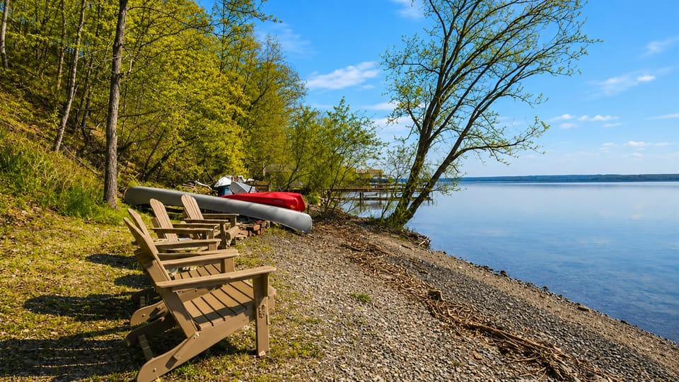 Lakefront / Boathouse / Dock (requires three flights of stairs to access)  -  Bask in the tranquility of our private lakeside beach, featuring comfortable loungers and direct water access, perfect for a serene day by the lake.