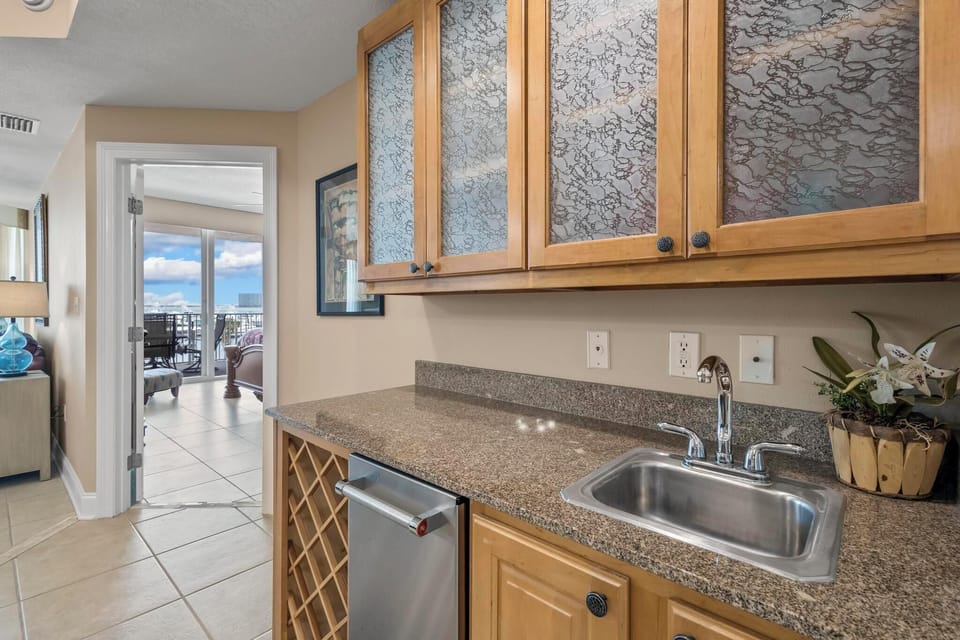 Wet Bar - A wet bar is provided which features an ice maker and beverage sink.