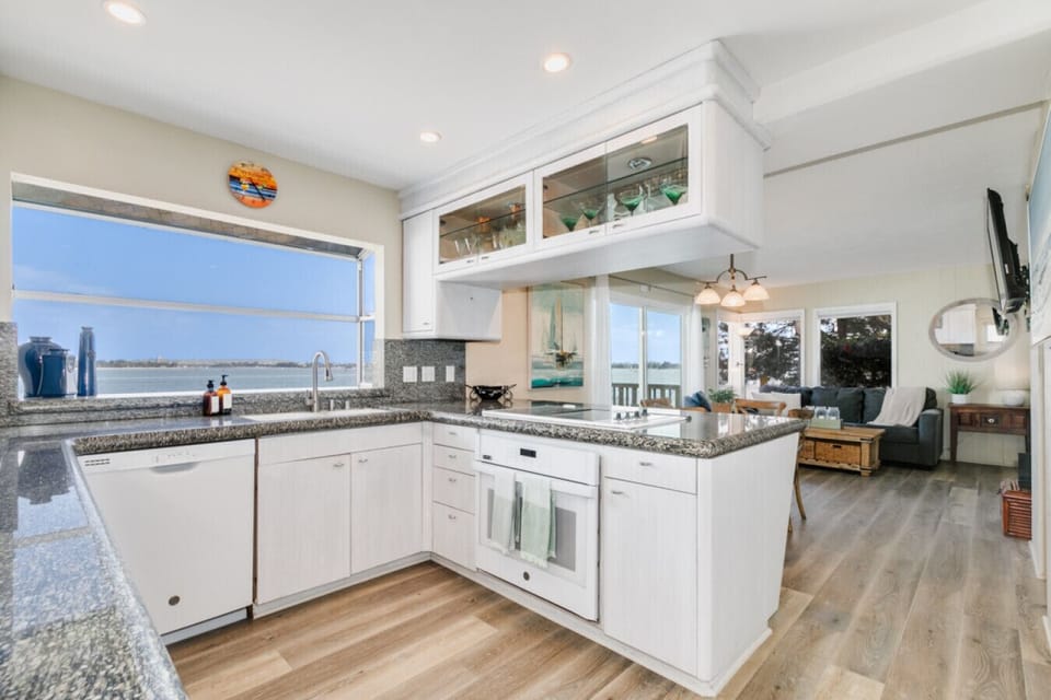 Modern kitchen with large windows, offering unobstructed water views while you cook, complete with ample amenities for culinary enthusiasts.