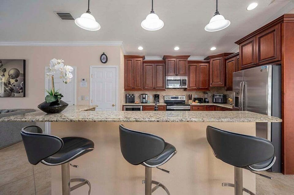 Kitchen With Bar Open to Living Room and Seating for Three