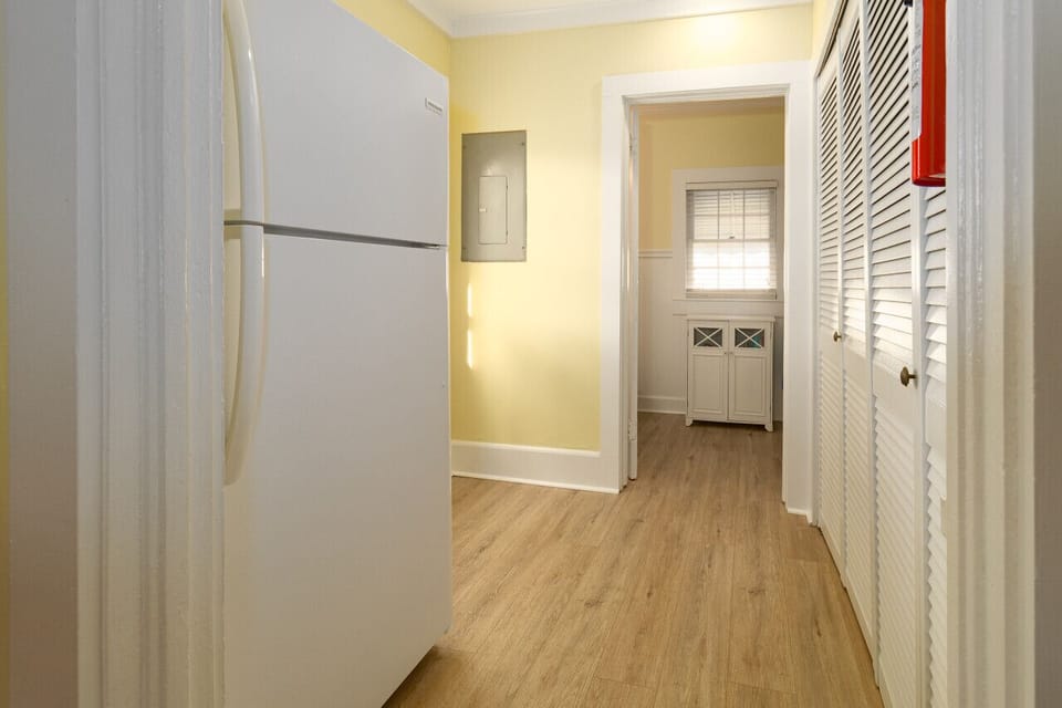 Fridge is located next to the kitchen in the hall.