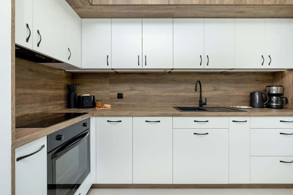 A modern kitchenette with white cabinets and plenty of natural light creates a bright and pleasant interior.