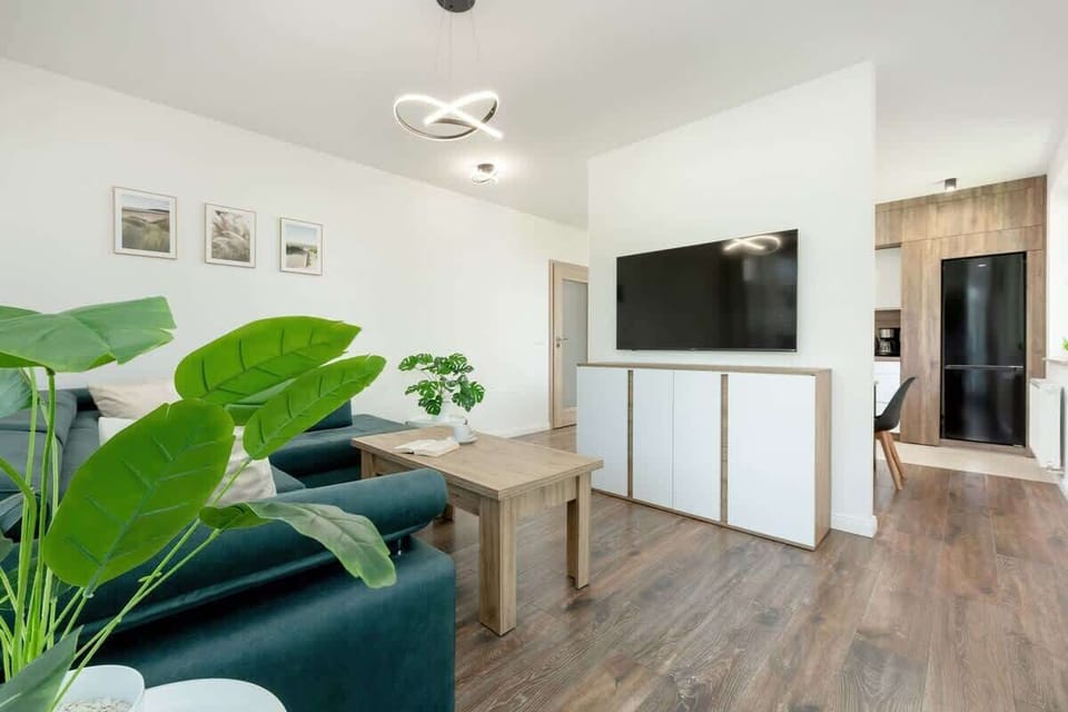 A living room with a dining area featuring a table, chairs, and decorative pictures on the wall combines functionality with aesthetics.