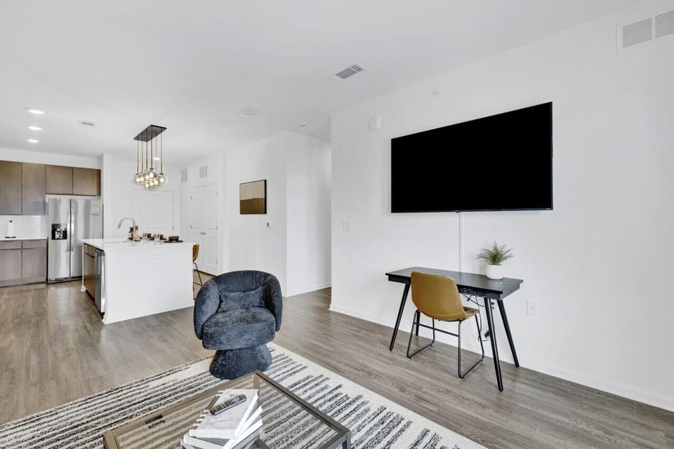 Relax in a stylish living area featuring a Smart TV and comfortable seating, perfect for unwinding during your short-term rental stay.