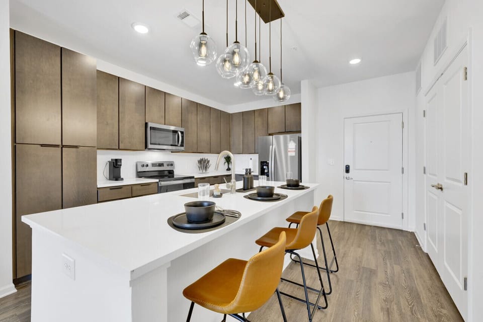 Modern kitchen with a sleek dining area, perfect for cooking, serving, and enjoying meals in style during your short-term rental stay