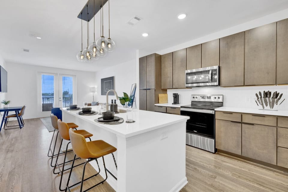 Modern kitchen with a sleek dining area, perfect for cooking, serving, and enjoying meals in style during your short-term rental stay