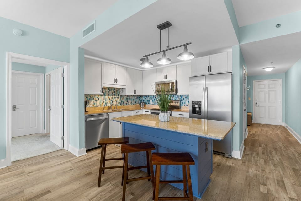 Modern kitchen with a blue island and stainless steel appliances