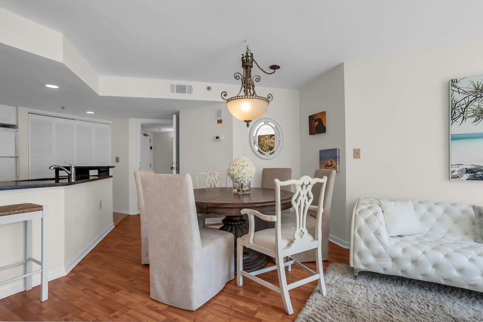 Your elegant open-plan living space blends dining and relaxation seamlessly with warm hardwood floors and sophisticated decor.