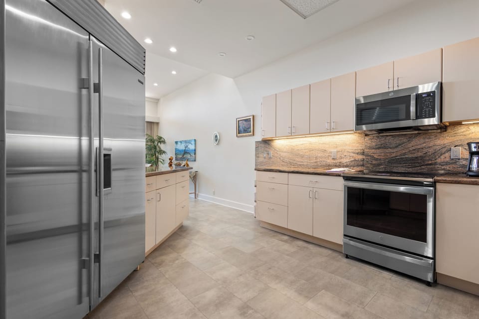 Prepare your favorite meals in this modern kitchen with stainless steel appliances, sleek cabinetry, and warm under-cabinet lighting that creates a welcoming cooking space for your stay.