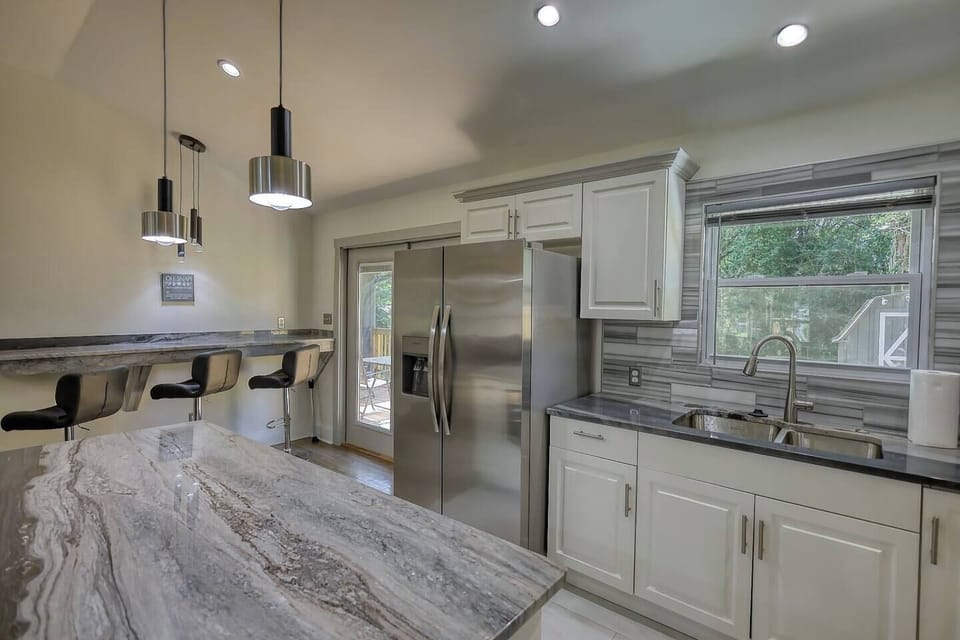 Kitchen features bar sitting with convenient access to patio.