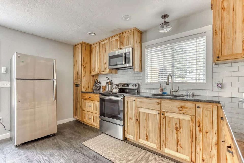 Rustic charm meets modern convenience in this fully equipped kitchen with natural wood cabinets, stainless appliances, and a bright, open feel.