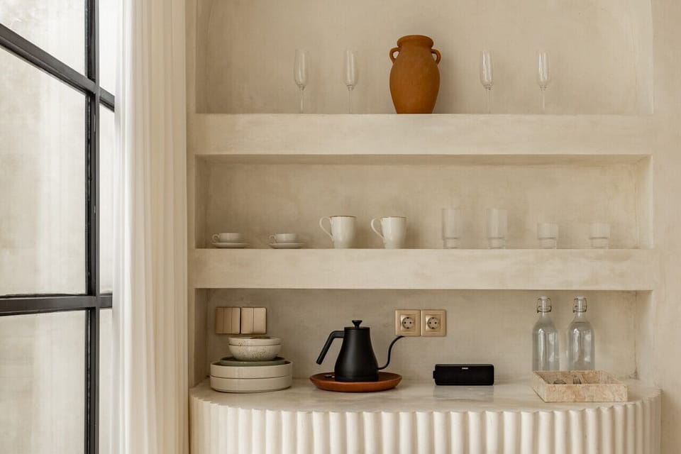 our villa interior featuring arched niches, a striped minibar, and rustic accents, all basking in natural light.