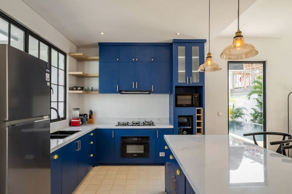 Spacious dining and kitchen area with a pop of blue and ample natural light.