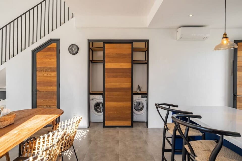 Efficient space with dining area and laundry nook under the stairs.