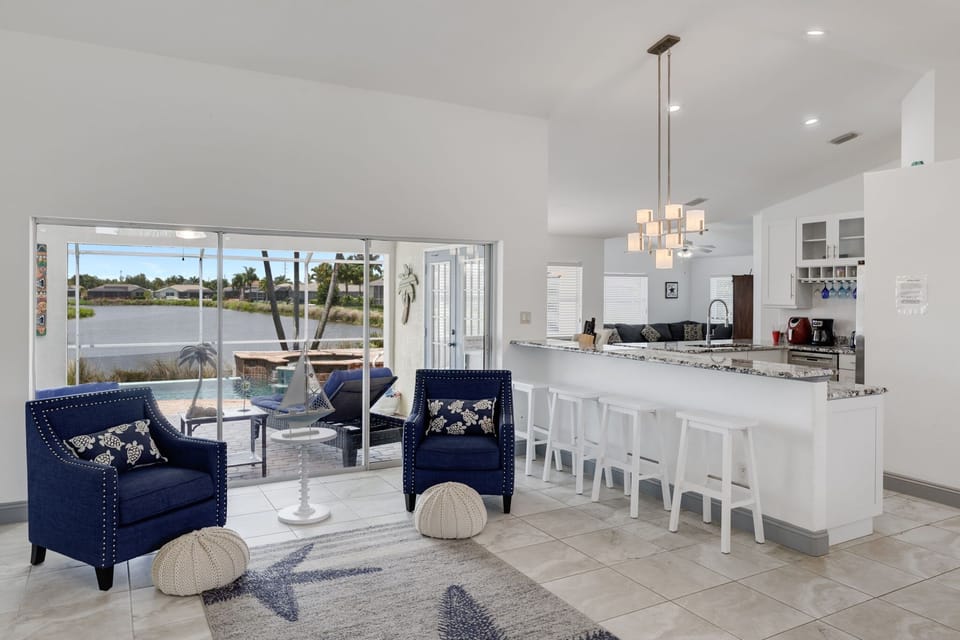 Expansive light filled living room overlooking peaceful lake and pool deck
