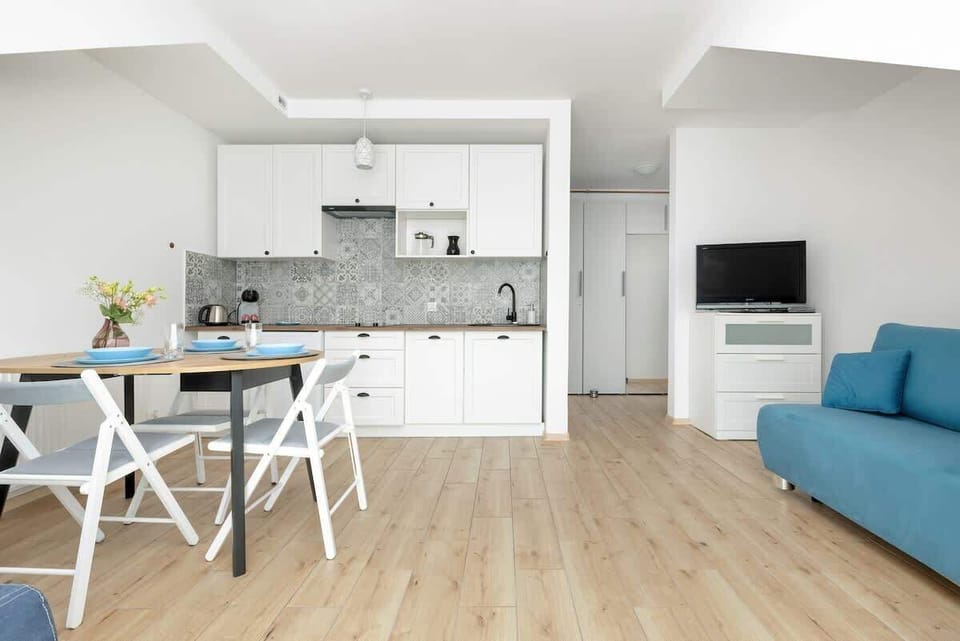  The living room with a dining area, featuring a table, chairs, and a blue sofa, combines functionality with aesthetics.