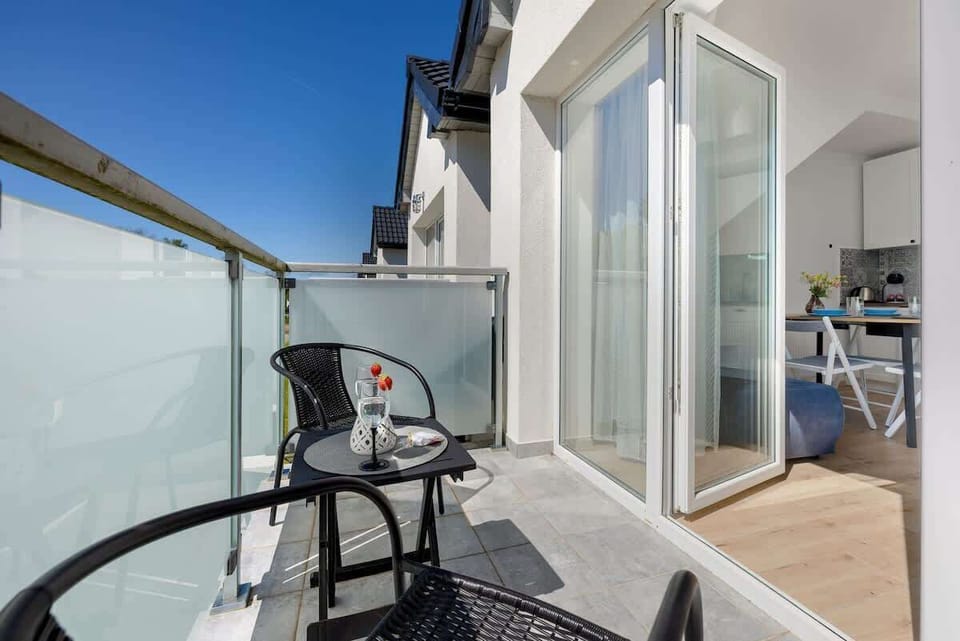 The view of the balcony with modern glass railings emphasizes the apartment’s style and open space.
