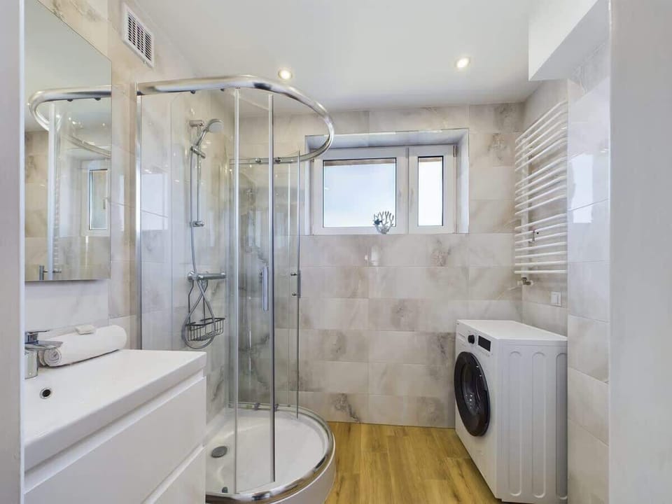 Elegant bathroom with glass-enclosed shower and contemporary fixtures.

