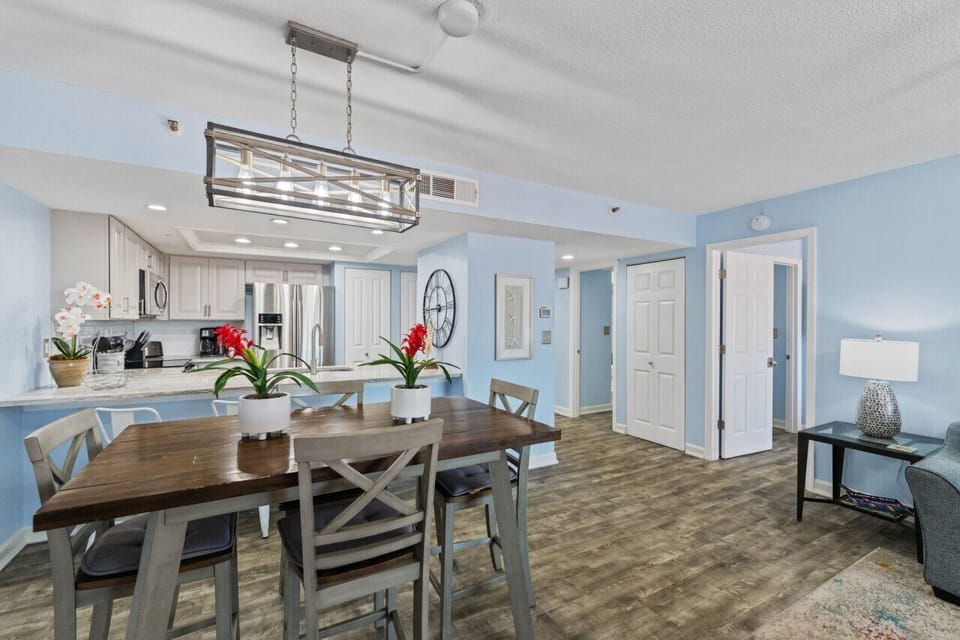 Spacious dining area w/ a long table, statement lighting, and nearby seating for groups.