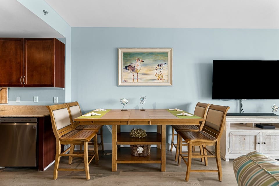 dining area with wooden table and chairs against a light blue wall