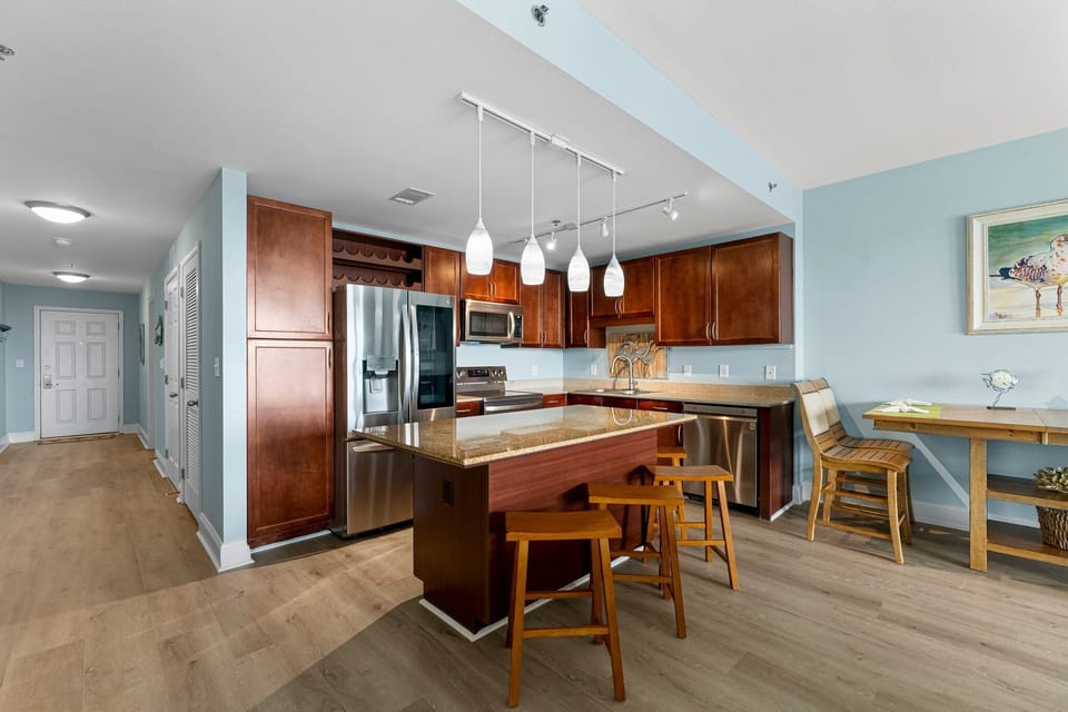 Modern kitchen with stainless steel appliances and a central island for casual dining.