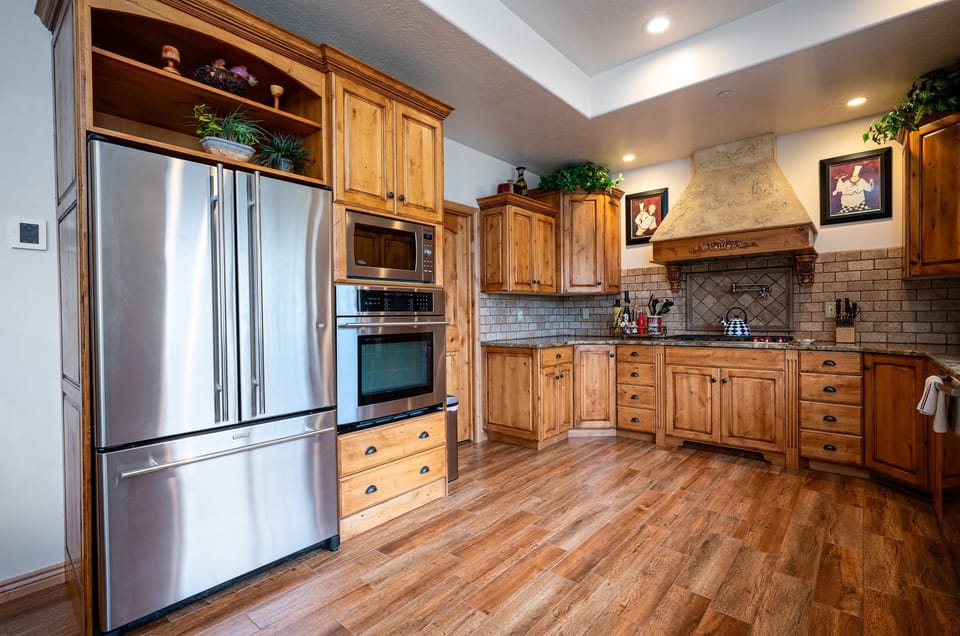 Indulge in culinary delight with a spacious refrigerator and a collection of contemporary appliances, comprising a stove, oven, microwave, and dishwasher.