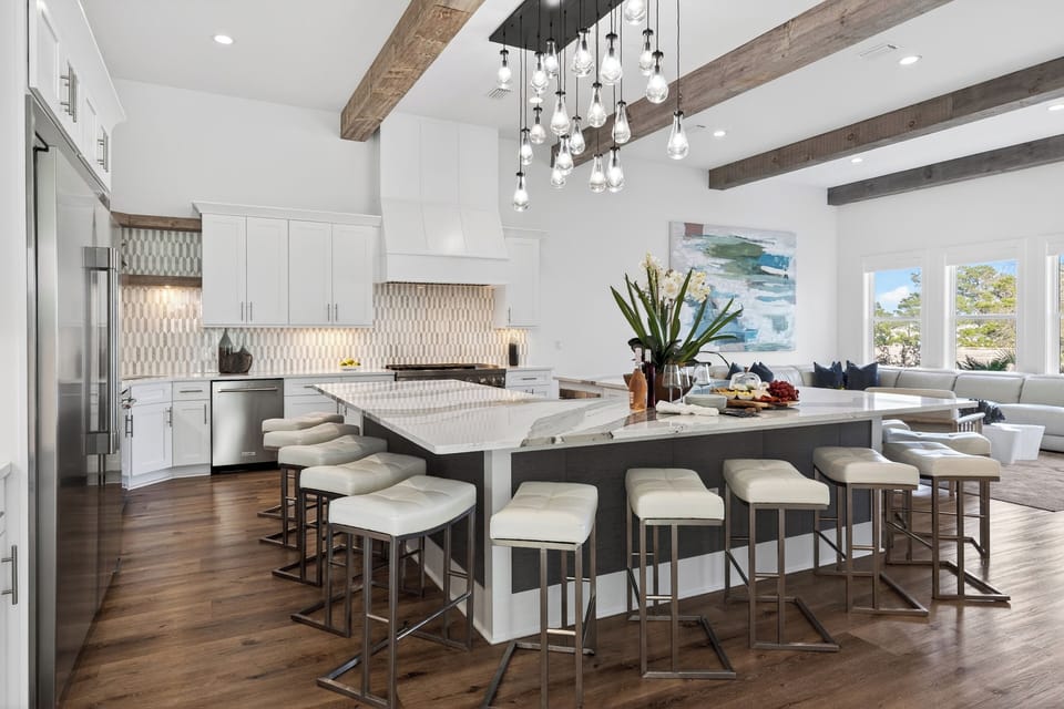 Sleek chef’s kitchen with a massive marble island, designer lighting, and plenty of seating for easy group meals and mingling.