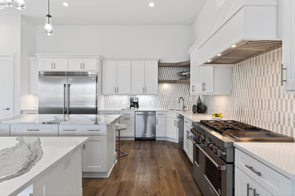 Sleek chef’s kitchen with a massive marble island, designer lighting, and plenty of seating for easy group meals and mingling.