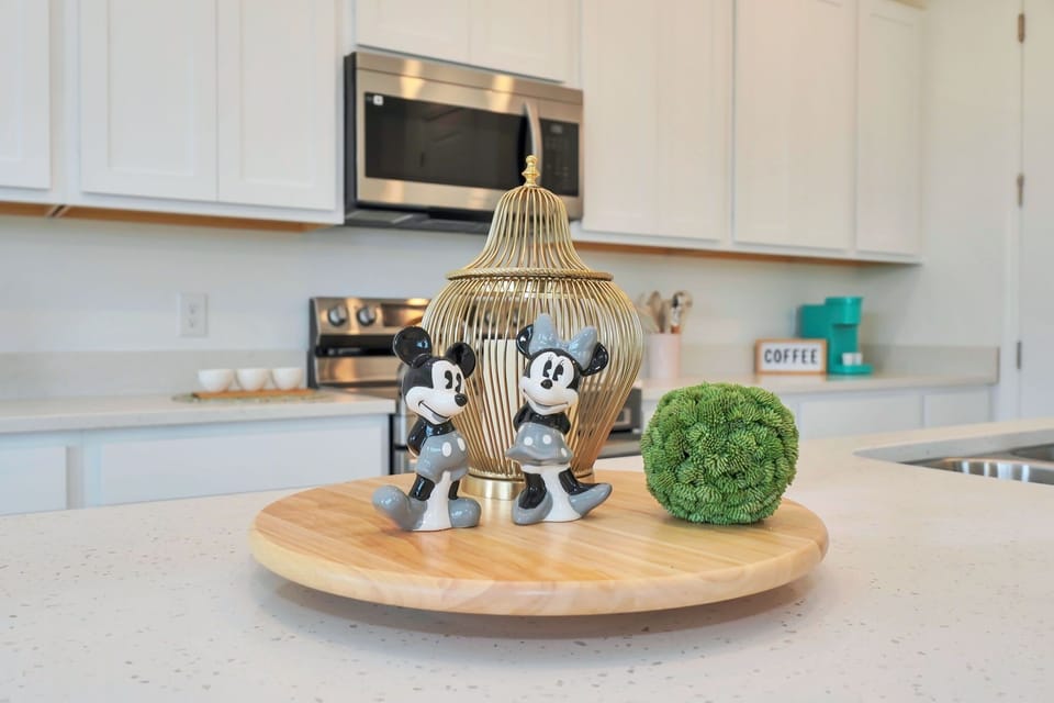 Modern kitchen countertop with decorative Mickey and Minnie figurines and stainless steel appliances