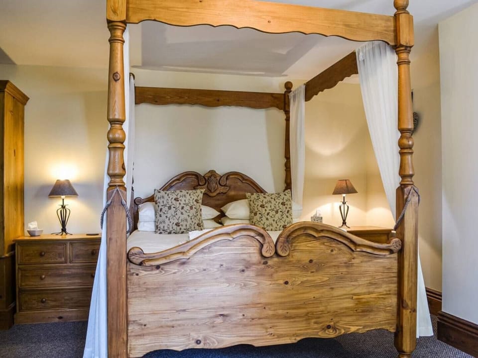 Four poster in master bedroom with sofa bed