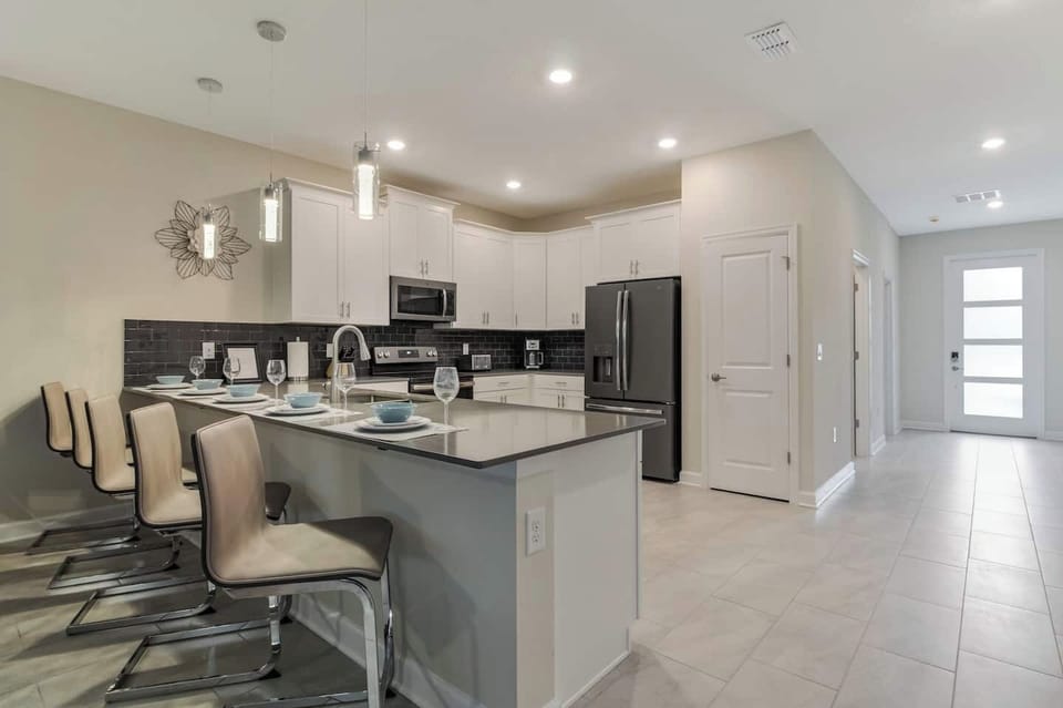 Sleek modern kitchen with island seating and stainless steel appliances, perfect for culinary adventures.