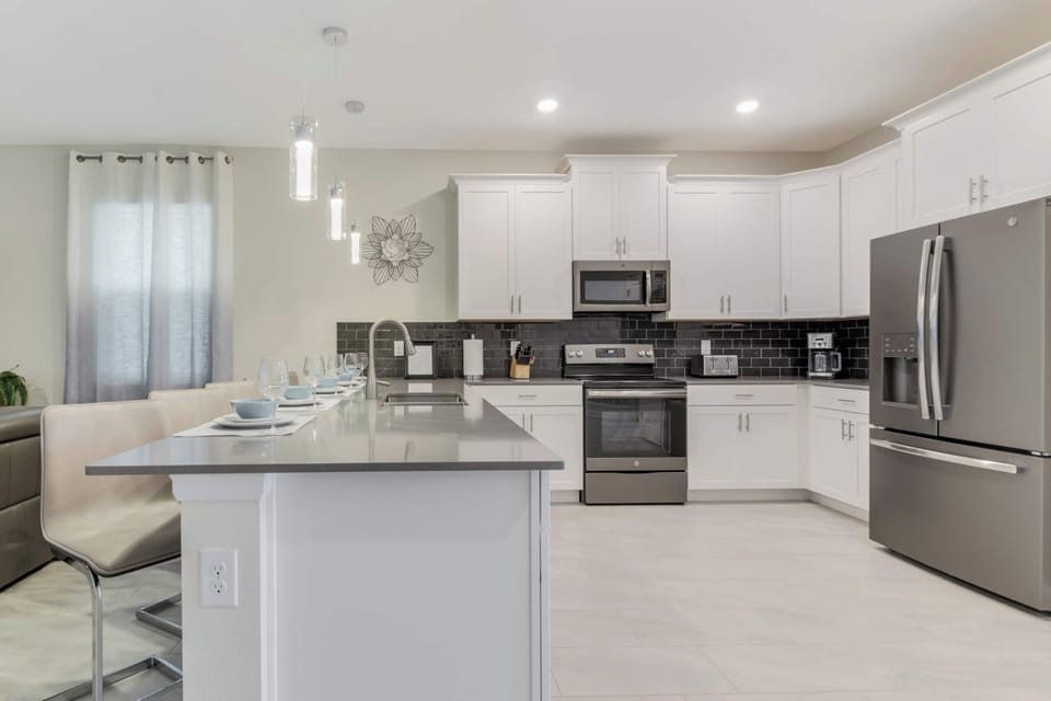 Sleek and modern kitchen with stainless steel appliances and a cozy breakfast bar, perfect for morning coffee or evening meals.