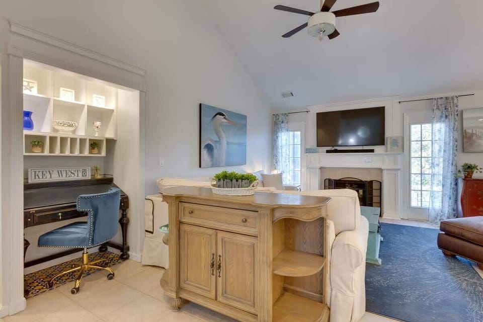 Relax in your bright coastal living room with sofa table workspace, built-in shelving, and fireplace for cozy evenings.