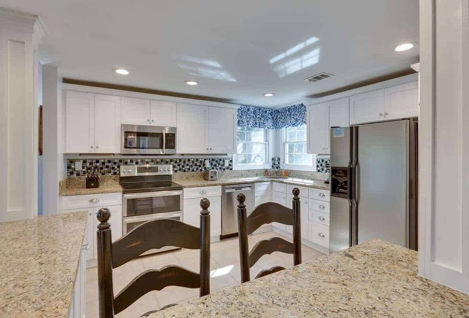 Your fully equipped kitchen features granite counters, modern appliances, and charming breakfast bar perfect for morning coffee.